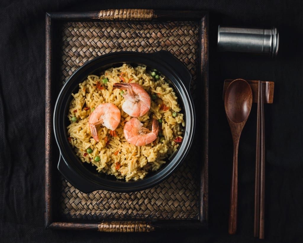Shrimp fried rice in a black pot on a dark table
